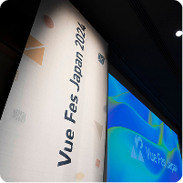 Vue Fes Japan 2024の縦型の垂れ幕とスクリーンが並んで表示されている会場の様子。