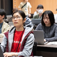 Vue Fes Japan 2024で登壇するAnthony。Vue Fes Japanのロゴ とスポンサーのロゴが並ぶバックパネルの前で、マイク越しに発表している。