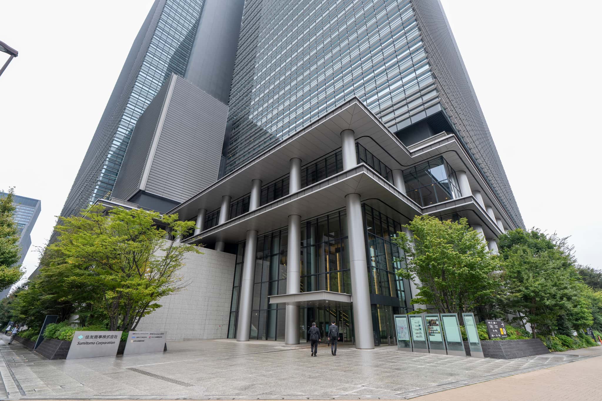 大手町プレイス ホール＆カンファレンス会場内の大きなセミナールーム。木目調の壁面と格子状の音響天井パネル、黒いスタッキングチェアが並べられている。